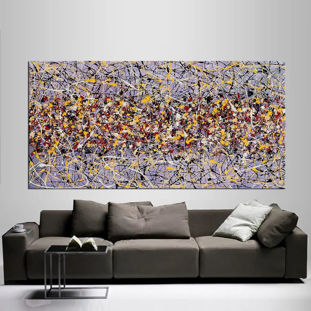 Action painting abstract art displayed above a modern sofa, showcasing vibrant colors and dynamic patterns.