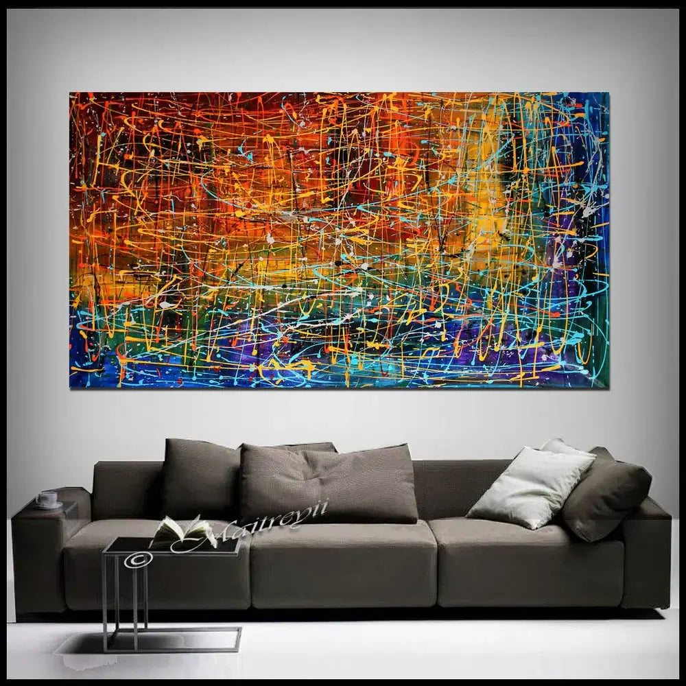 Multicolored Abstract Painting titled Embracing Fire displayed above a modern sofa in a stylish interior.