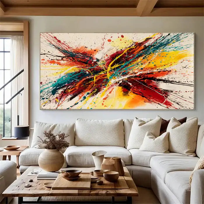 Abstract canvas painting displayed in a modern living room, featuring bold colors and splatter design.