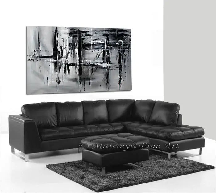 Black and White Large Painting displayed above a black leather couch in a modern living room setting.