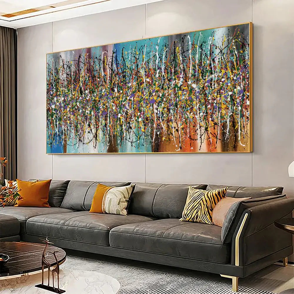 Contemporary Abstract Drip Painting displayed in a modern living room with a dark sofa and colorful pillows.