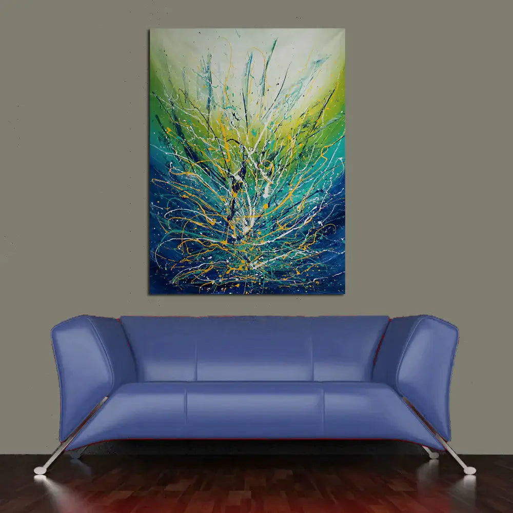 Painting Jackson Pollock Multiple Size displayed above a modern blue couch, showcasing vibrant drip art in turquoise and green.