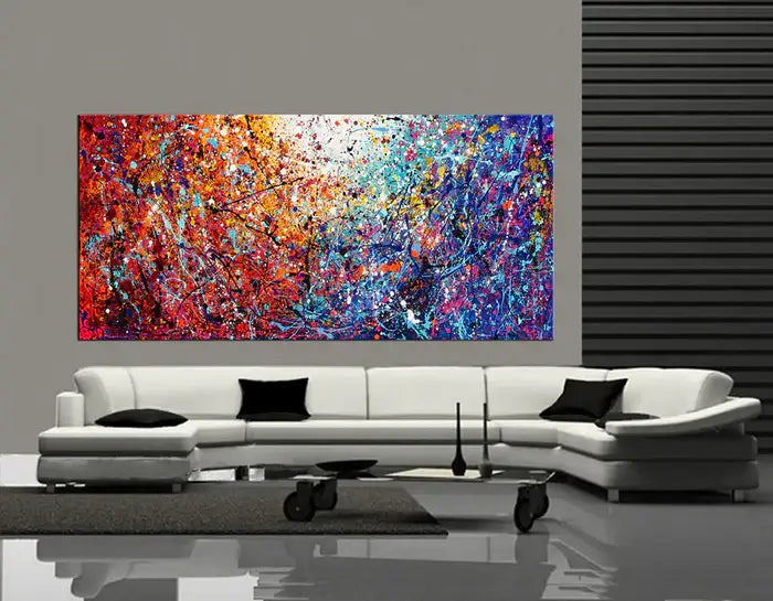 Drip painting on canvas displayed above a modern sofa, showcasing vibrant colors and dynamic splatter technique.