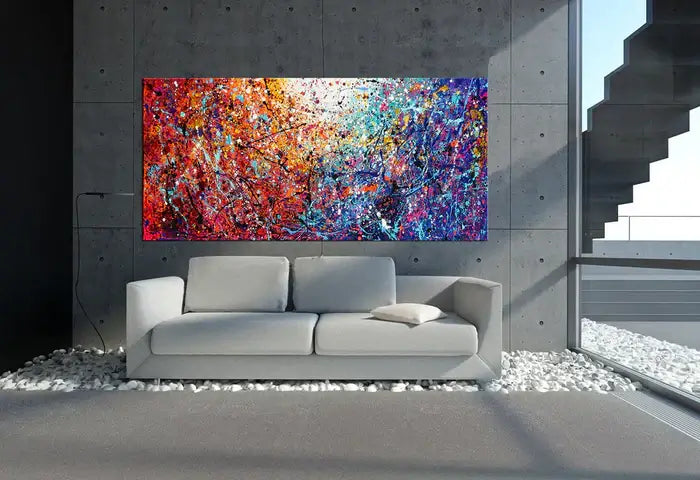 Drip painting on canvas displayed in a modern living room featuring vibrant colors and abstract splatter design.