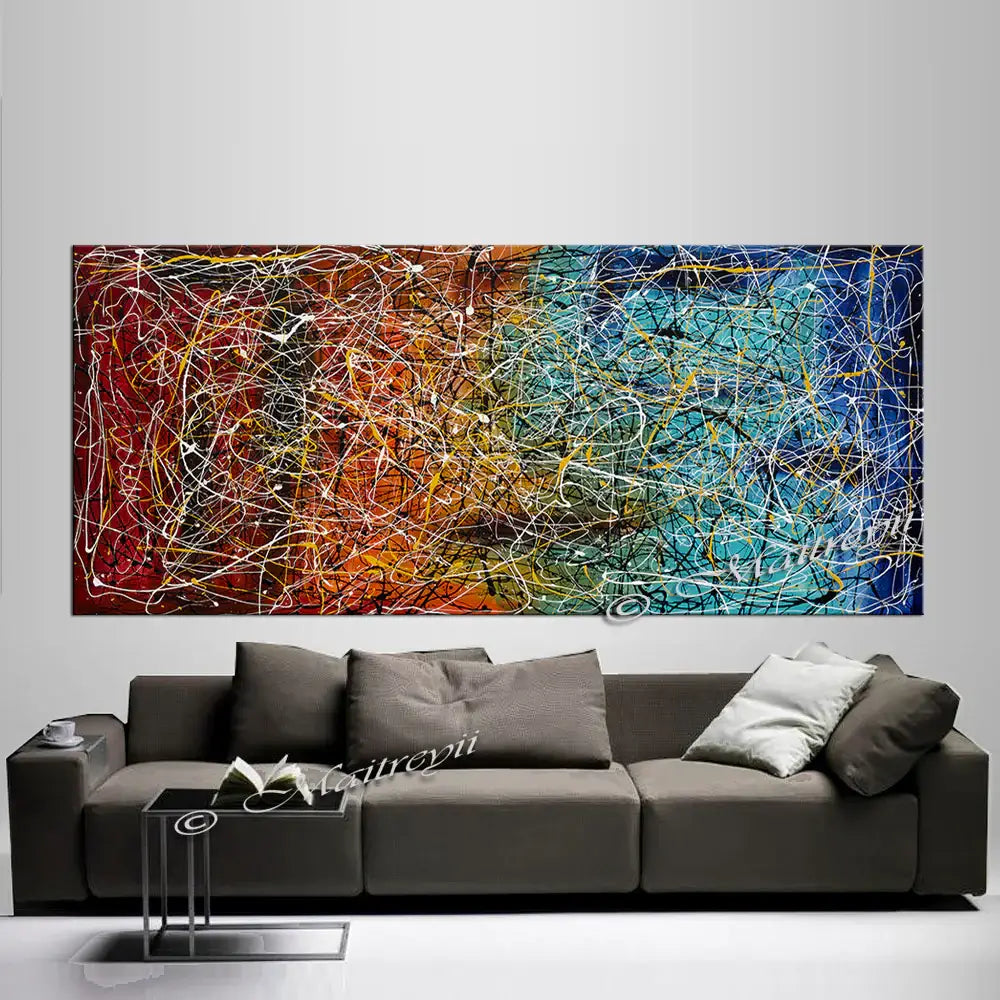 Jackson Pollock Style abstract canvas wall art hanging above a modern grey couch in a bright living room.