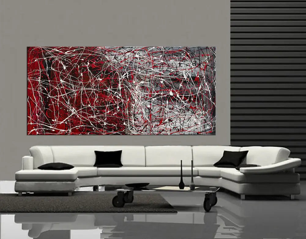 Drip painting on canvas showcasing abstract red and silver wall art above a modern white sofa in a stylish interior.