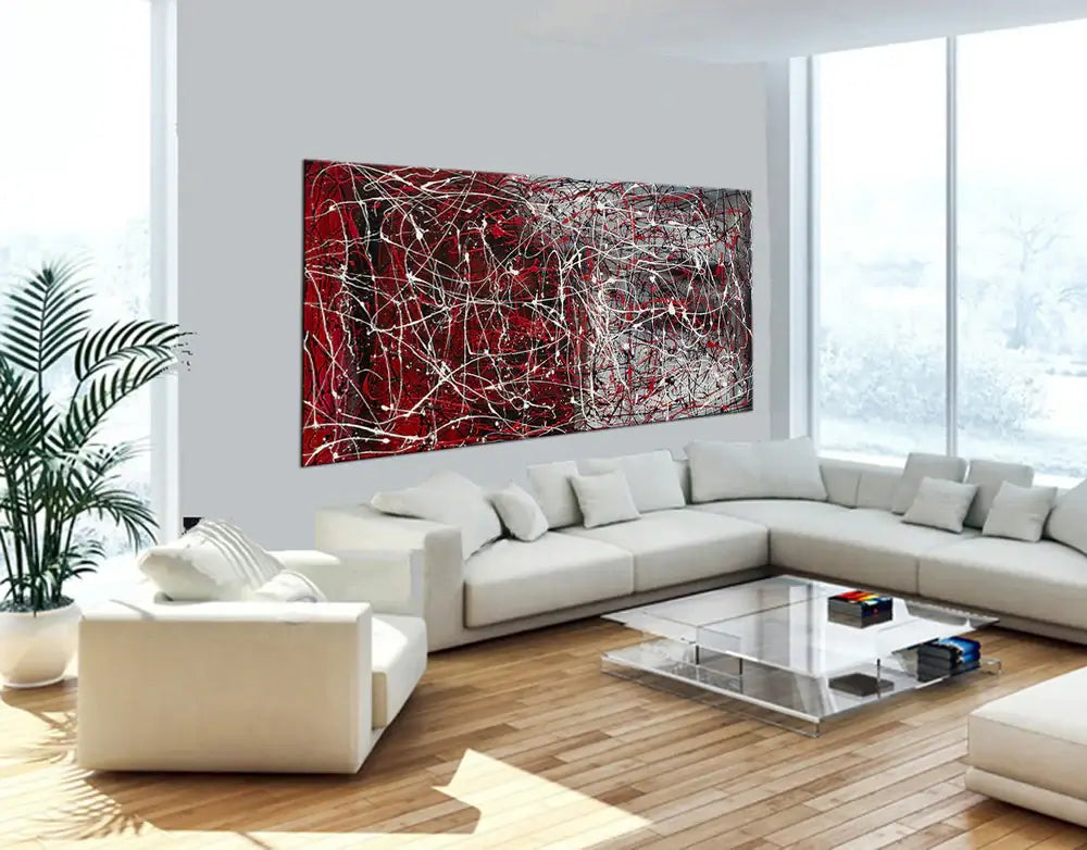 Drip painting on canvas in a modern living room, showcasing vibrant red abstract wall art for home decor.