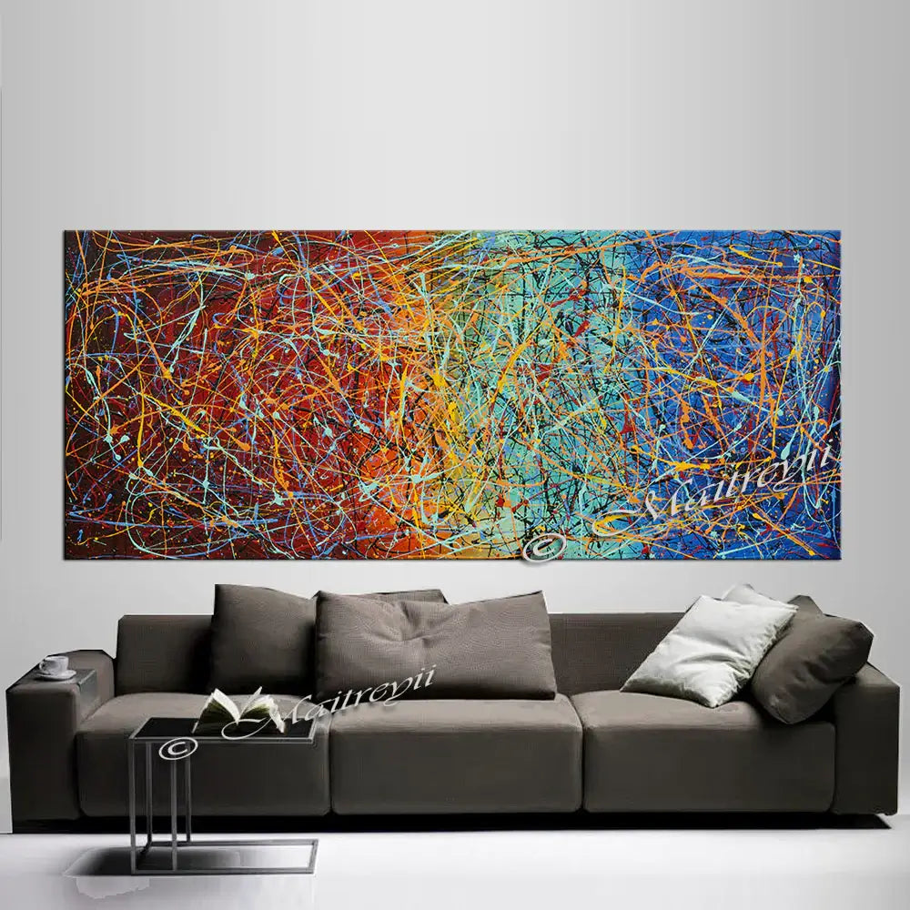 Jackson Pollock Style abstract canvas wall art displayed above a modern gray sofa in a stylish living room setting.