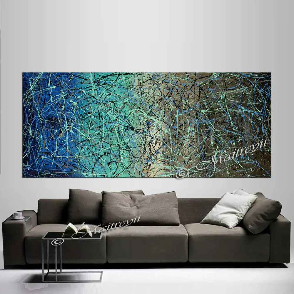 Jackson Pollock Style abstract canvas wall art above a modern gray sofa, featuring vibrant blue and green colors.