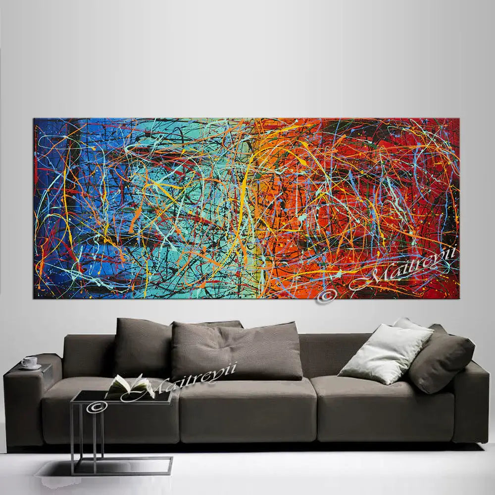 Jackson Pollock Style abstract canvas wall art displayed above a stylish gray sofa in a modern living room.