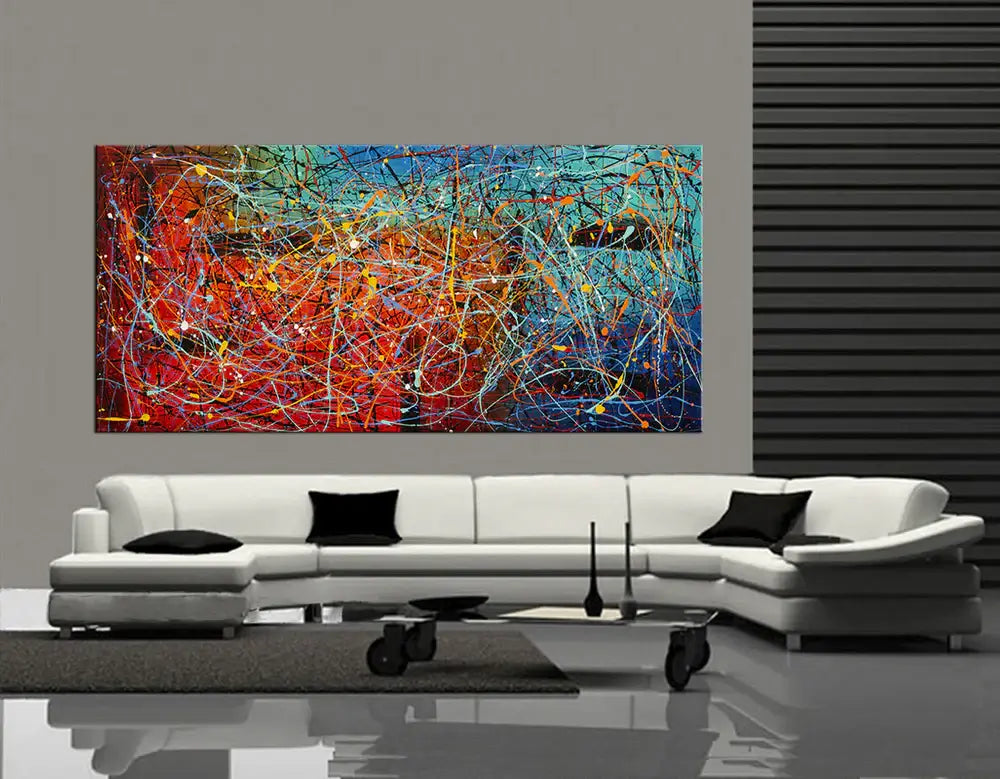 Jackson Pollock Style Painting displayed on a modern living room wall above a white sofa, showcasing vibrant abstract drip art.
