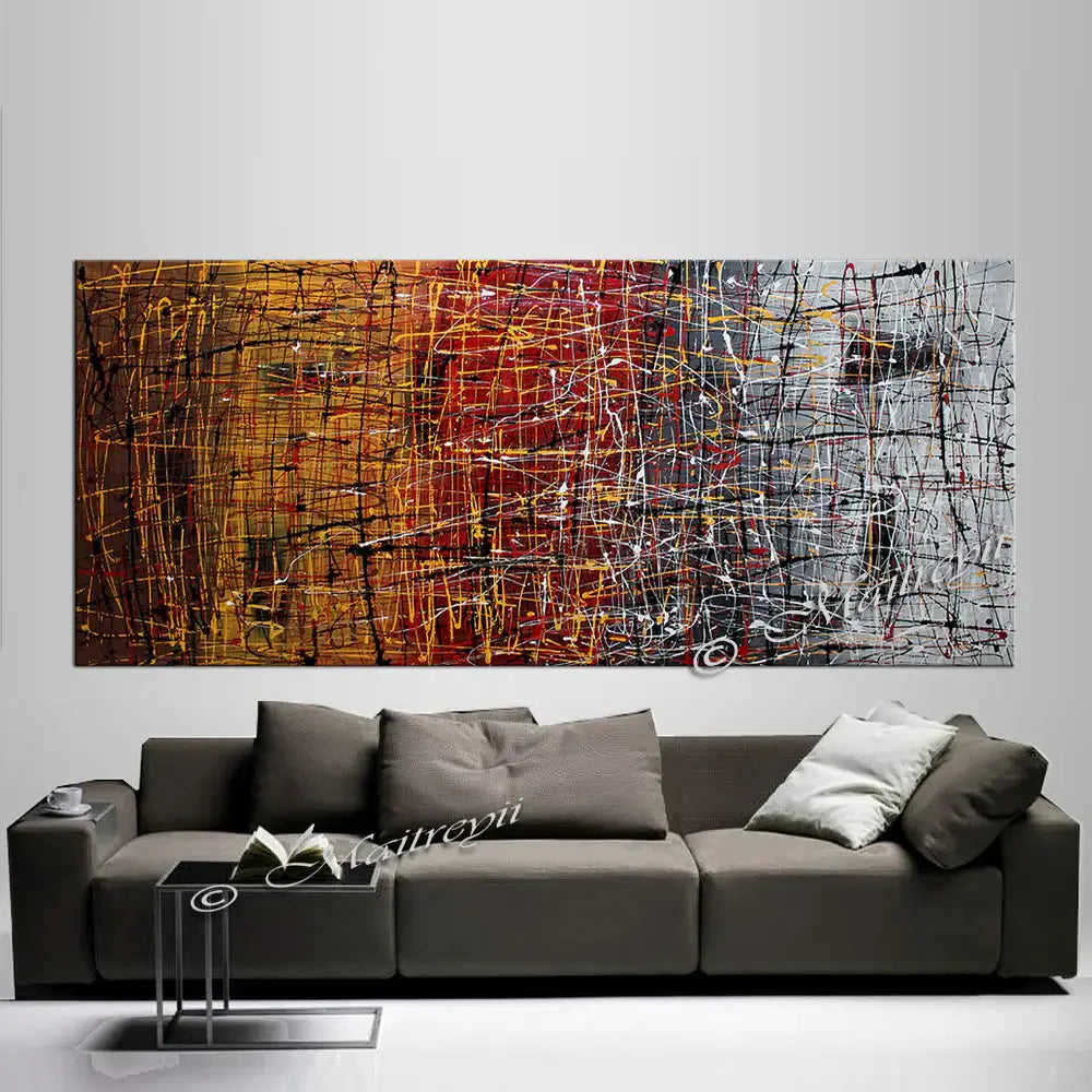 Pollock Inspired Art on a modern living room wall above a gray sofa, showcasing dynamic colors and abstract expressionism.