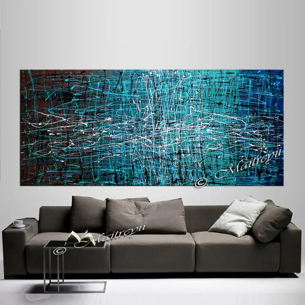 Abstract drip painting on a wall above a modern sofa, showcasing vibrant colors and expressive textures.