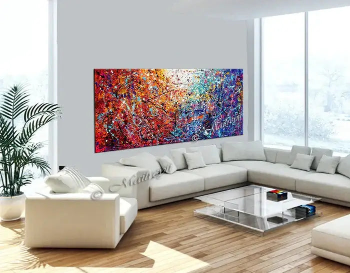 Painted abstract art displayed in a modern living room, featuring vibrant colors and dynamic textures on canvas.
