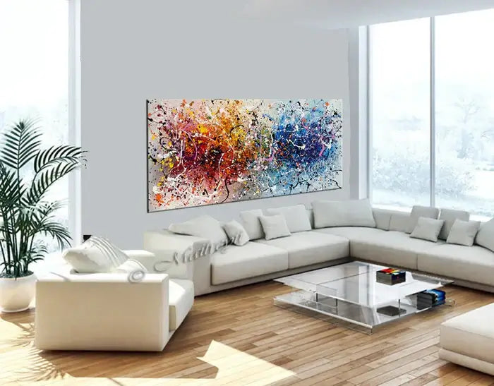 Vibrant hand-painted canvas wall art in modern living room with white furniture and bright natural light.