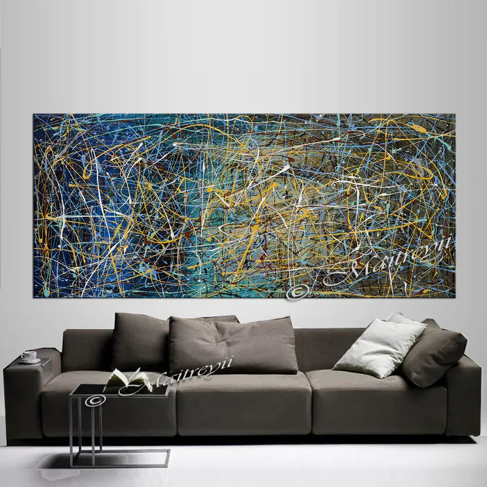 Abstract art – modern hand-painted canvas displayed above a stylish gray sofa in contemporary home décor.