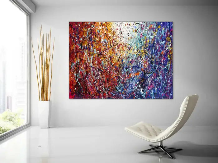 Painted abstract art displayed in a modern interior, featuring vibrant colors and dynamic textures on canvas.