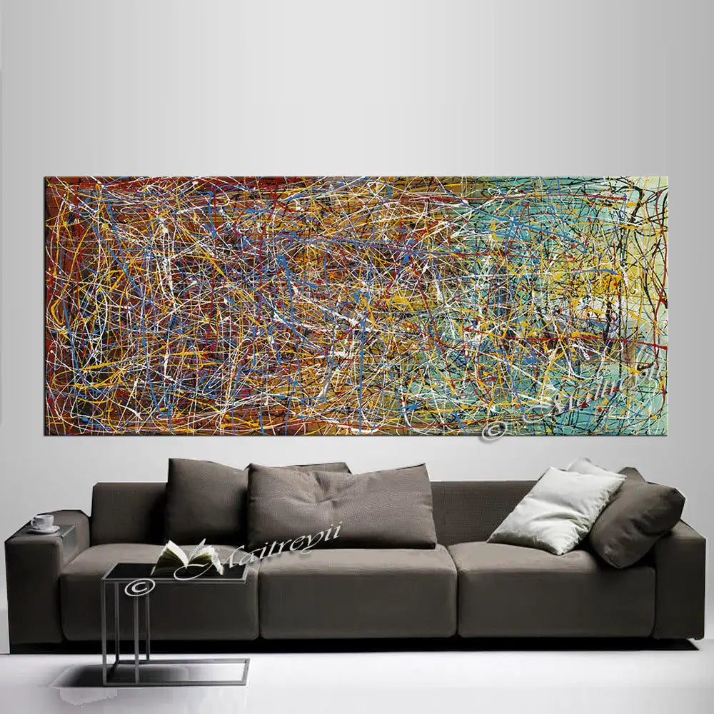 Jackson Pollock Style abstract artwork painting displayed above a modern sofa, showcasing energetic drips and bold colors.