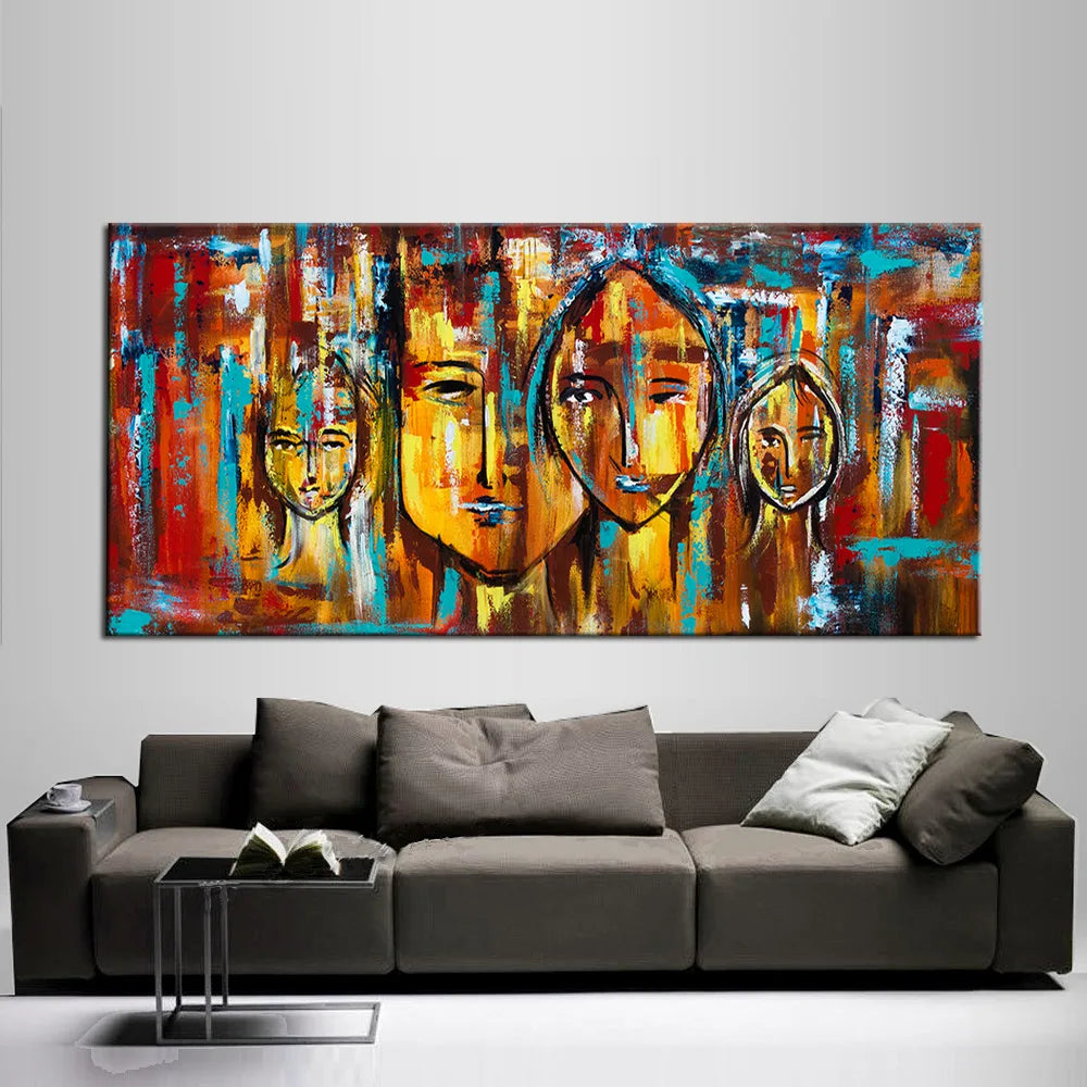 Colorful abstract painting of faces on a wall above a gray sofa.